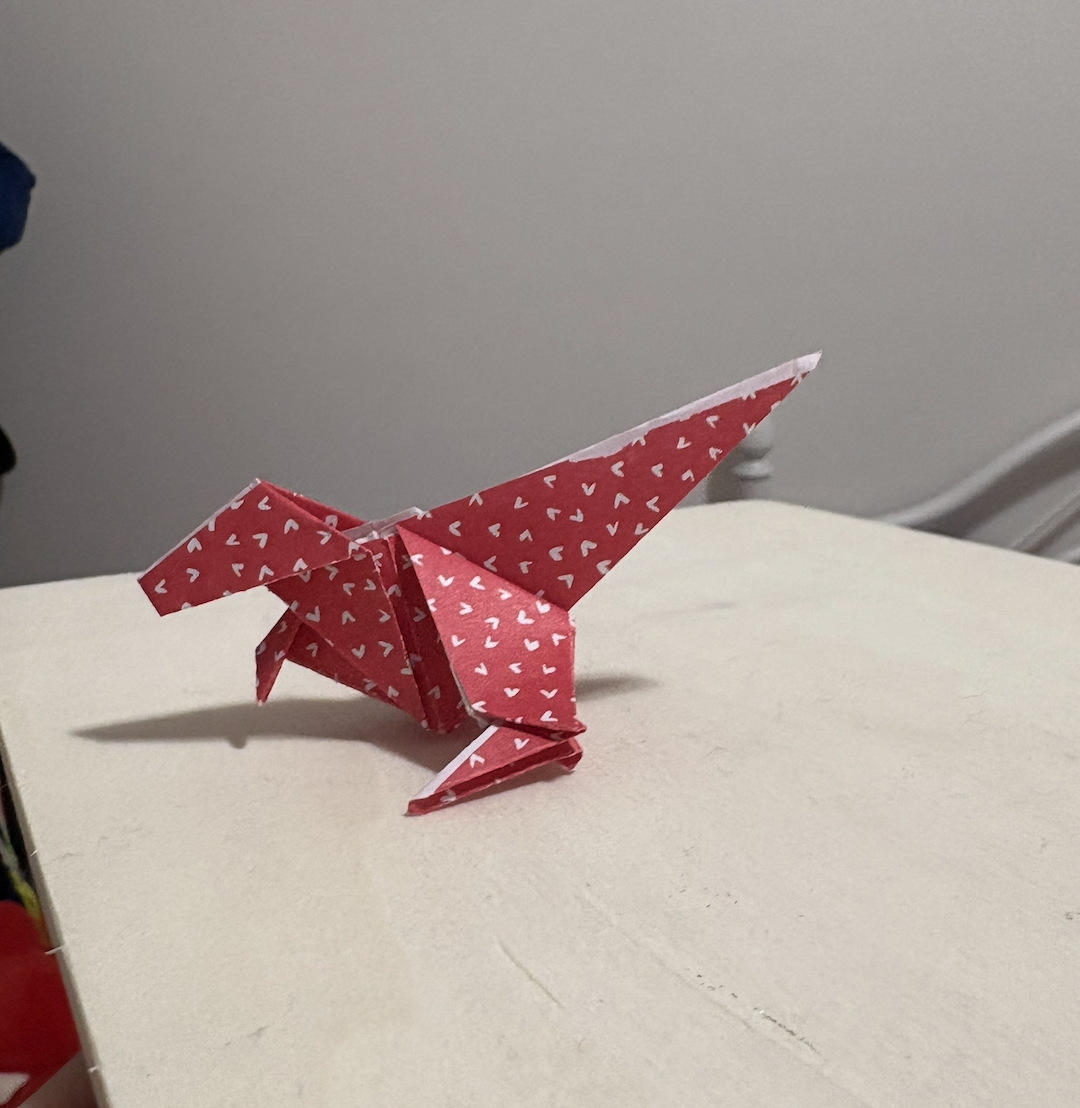 Dinosaur origami, interaction could be on the arms or flaps or the paper origami.
